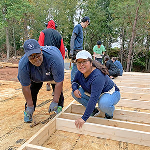Future homeowner Fay Hill and volunteers on the Kinda Tiny Homes build site