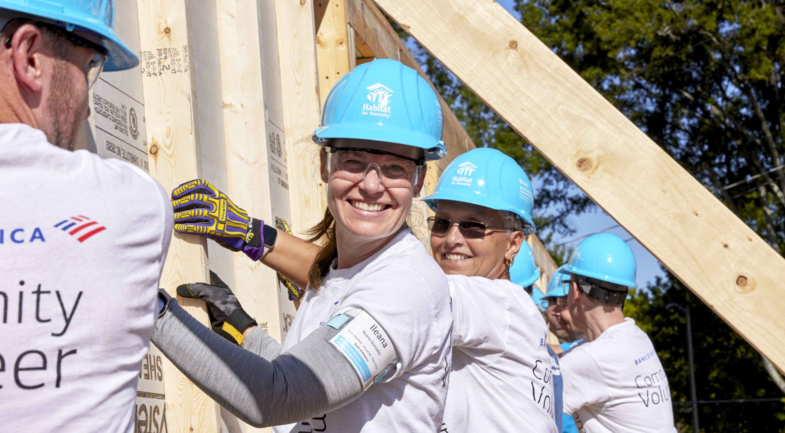 Volunteers from Bank of America help raise a wall at a Habitat for Humanity construction site